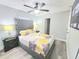 Bedroom featuring a gray tufted headboard, ceiling fan, and laminate flooring at 509 Grove Ave, Orlando, FL 32805