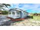 Side view of a charming blue home with a covered porch and neatly mulched landscaping at 509 Grove Ave, Orlando, FL 32805