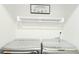 Bright laundry room featuring modern washer and dryer with sleek design, and useful shelving above at 509 Grove Ave, Orlando, FL 32805
