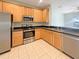 Efficient kitchen with stainless appliances, tile floor, and ample wood cabinets at 5236 Shale Ridge Trl, Orlando, FL 32818