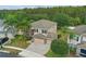 Aerial view of a home with stone accents, a three-car garage, and lush landscaping in a residential neighborhood at 5525 Oakworth Pl, Sanford, FL 32773
