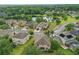 Aerial view of homes in a neighborhood, pond, and lush surrounding landscape at 5525 Oakworth Pl, Sanford, FL 32773
