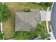 Aerial view showcases roof, landscaping, driveway and mature trees. The home is nestled on a corner lot at 5525 Oakworth Pl, Sanford, FL 32773
