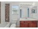 Bright bathroom featuring a tiled shower, marble countertop, and window for natural light at 5525 Oakworth Pl, Sanford, FL 32773