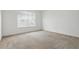A bright bedroom featuring neutral carpet, white walls, and a window with blinds at 5525 Oakworth Pl, Sanford, FL 32773