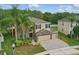 Beautiful suburban home showcasing stone detailing, a three-car garage, and a well-maintained yard with mature trees at 5525 Oakworth Pl, Sanford, FL 32773