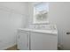 Bright laundry room with washer, dryer, storage shelf, and natural light from window at 5525 Oakworth Pl, Sanford, FL 32773