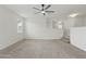 Expansive living room with ceiling fan, stairs, and neutral carpet at 5525 Oakworth Pl, Sanford, FL 32773