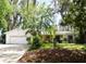 Charming home featuring a spacious front yard with mature trees and an attached two-car garage at 6105 Lost Tree Court, Orlando, FL 32808