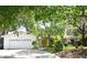 Inviting home showcasing a well-kept front yard, mature trees, and a convenient two-car garage at 6105 Lost Tree Court, Orlando, FL 32808