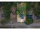 An aerial view of a home with a blue roof surrounded by lush trees and neighboring homes at 6345 Hatcher Rd, Lakeland, FL 33811