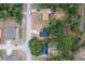 Aerial view of houses on a street with lush green trees; one has a pool, and another has a red patio umbrella at 6345 Hatcher Rd, Lakeland, FL 33811