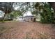 A view of the back of the house featuring a backyard with scattered foliage and a small wooden deck at 6345 Hatcher Rd, Lakeland, FL 33811