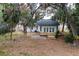 Back view of house with deck, mature trees, and wooden privacy fence and gate at 6345 Hatcher Rd, Lakeland, FL 33811