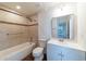 Bright bathroom featuring tiled shower and tub, wood floors, white vanity and new mirror, and great light at 6345 Hatcher Rd, Lakeland, FL 33811