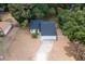 Aerial view of a fenced in yard with mature trees and a bright white home with a new dark roof and a two-car garage at 6345 Hatcher Rd, Lakeland, FL 33811