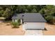 Charming home features a two-car garage, fresh exterior paint, a well maintained lawn, and lush landscaping at 6345 Hatcher Rd, Lakeland, FL 33811