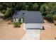 A bright aerial view of a white home with a new dark roof, two-car garage, and palm trees at 6345 Hatcher Rd, Lakeland, FL 33811