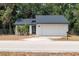 Charming single-story home featuring a white exterior, a two-car garage, and well-maintained landscaping at 6345 Hatcher Rd, Lakeland, FL 33811