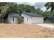 Charming single-story home featuring a white exterior, a two-car garage, and well-maintained landscaping at 6345 Hatcher Rd, Lakeland, FL 33811