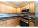 Modern kitchen showcasing stainless steel appliances, wood cabinets and granite countertops at 6345 Hatcher Rd, Lakeland, FL 33811