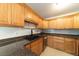 Well-lit kitchen featuring wood cabinets, a granite countertop, and stainless steel appliances at 6345 Hatcher Rd, Lakeland, FL 33811