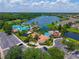 A serene aerial view of the community pool complex, community clubhouse, and lake at 6542 Lake Pembroke Pl, Orlando, FL 32829