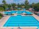Aerial view of a community pool featuring multiple pools, palm trees, and resort-style amenities at 6542 Lake Pembroke Pl, Orlando, FL 32829