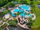 Aerial view of a community pool featuring water slides, a splash pad, and multiple pools and palm trees at 6542 Lake Pembroke Pl, Orlando, FL 32829