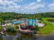 Aerial view of a community pool and waterpark, with a pirate ship and lake, surrounded by tropical landscaping at 6542 Lake Pembroke Pl, Orlando, FL 32829