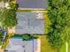 Bird's eye view of a home with a gray roof and a paved patio in the backyard at 6542 Lake Pembroke Pl, Orlando, FL 32829