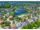 Aerial view of neighborhood, lake, and a subject home with a back patio and red location marker at 6542 Lake Pembroke Pl, Orlando, FL 32829