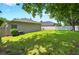 Lush backyard featuring a well-maintained lawn, mature trees, and a privacy fence for serene outdoor enjoyment at 6542 Lake Pembroke Pl, Orlando, FL 32829