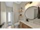 Tastefully decorated bathroom featuring stylish vanity, round mirror, and modern lighting fixtures at 6542 Lake Pembroke Pl, Orlando, FL 32829