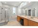Bright en-suite bathroom featuring double sinks, soaking tub, glass shower and large window at 6542 Lake Pembroke Pl, Orlando, FL 32829