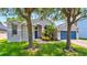 Beautiful single-story home with a well-manicured lawn, arched entryway, and a vibrant blue front door at 6542 Lake Pembroke Pl, Orlando, FL 32829