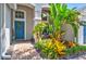 Up close view of the front entrance with decorative landscaping and a bright blue door with wreath at 6542 Lake Pembroke Pl, Orlando, FL 32829
