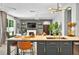 Open floorplan with kitchen island featuring bar seating, quartz countertops, stainless appliances and views of the living area at 6542 Lake Pembroke Pl, Orlando, FL 32829