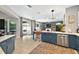 Open kitchen with island, stainless steel appliances, and bar seating overlooks the living area and outdoor patio at 6542 Lake Pembroke Pl, Orlando, FL 32829