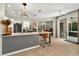 Open kitchen features an island with bar seating, modern lighting, and overlooks the entry and outdoor patio at 6542 Lake Pembroke Pl, Orlando, FL 32829