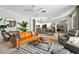 Comfortable living room featuring a leather couch, ceiling fan, and view of the open kitchen area at 6542 Lake Pembroke Pl, Orlando, FL 32829
