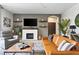 Comfortable living room featuring a white fireplace, decorative shelves, ceiling fan, and large tile flooring at 6542 Lake Pembroke Pl, Orlando, FL 32829