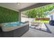 Relaxing outdoor patio featuring a hot tub, dining area, and green wall at 6542 Lake Pembroke Pl, Orlando, FL 32829