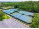 Aerial view of the tennis courts with green surface and blue in-bounds, near the parking lot at 6542 Lake Pembroke Pl, Orlando, FL 32829
