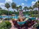 Community waterpark with a lighthouse-themed slide and a pool, surrounded by lush landscaping and palm trees at 6542 Lake Pembroke Pl, Orlando, FL 32829