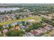 Aerial view of a suburban neighborhood featuring mature trees, a lake, and neatly landscaped yards at 6702 Imperial Oak Ln, Orlando, FL 32819