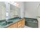 Bathroom featuring double sinks, a shower with glass door, and separate green-tiled tub at 6702 Imperial Oak Ln, Orlando, FL 32819