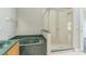 Bathroom featuring a glass-enclosed shower and a soaking tub with green tile surround at 6702 Imperial Oak Ln, Orlando, FL 32819