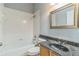 Bathroom with a white tub, tiled walls, and a vanity with a granite countertop at 6702 Imperial Oak Ln, Orlando, FL 32819
