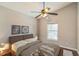 Serene bedroom with neutral walls, a ceiling fan, and a large window overlooking the backyard at 6702 Imperial Oak Ln, Orlando, FL 32819